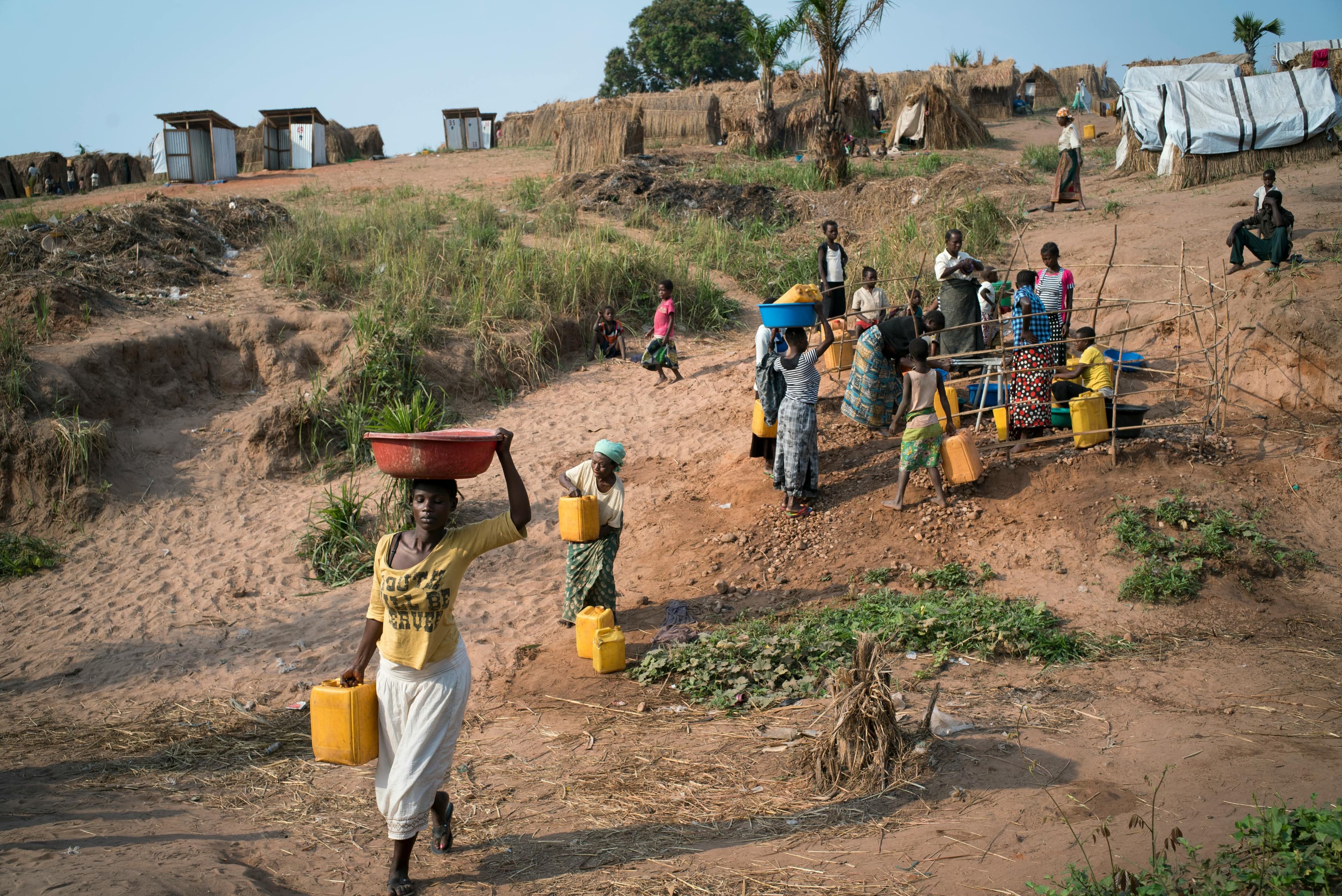 Women carrying water in basins and jerrycans